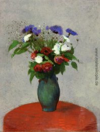 Vase mit Blumen auf einer roten Tischdecke
